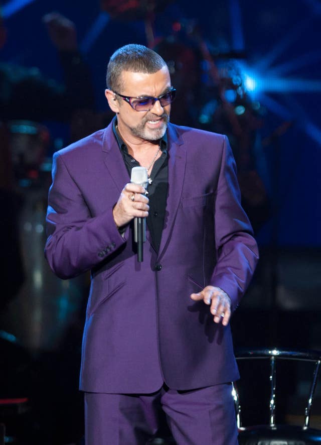 George Michael performing on stage, wearing a purple suit