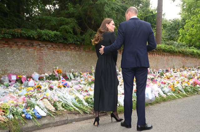 The Prince and Princess of Wales view floral tributes left by members of the public at the gates of Sandringham House in Norfolk