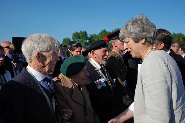 Prime Minister Theresa May speaks with D-Day veterans at the inauguration of the British Normandy Memorial site in Ver-sur-Mer, France