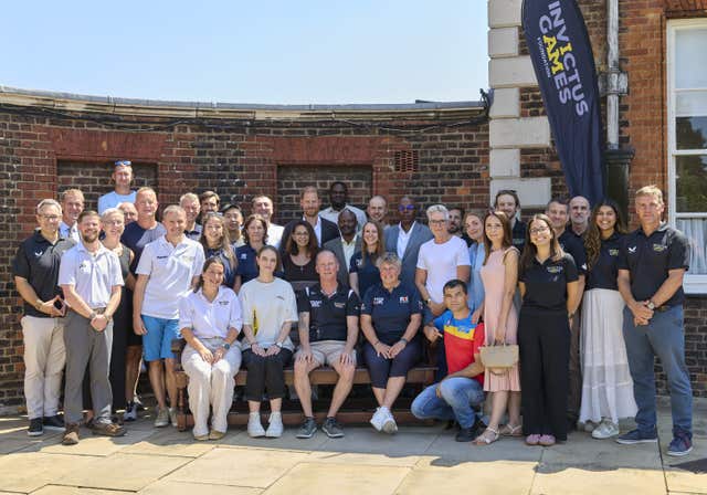 Harry outside in the middle of a group photo in the sunshine at the Royal Hospital Chelsea