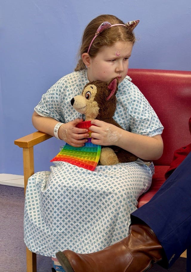 Catherine L’Estrange holding a teddy in a hospital gown
