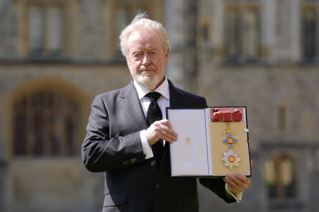 Sir Ridley Scott holding up his royal honour at Windsor Castle