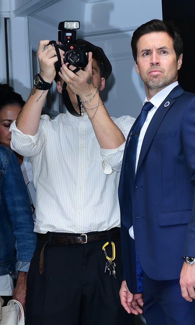Brooklyn Beckham takes a photograph after attending the show