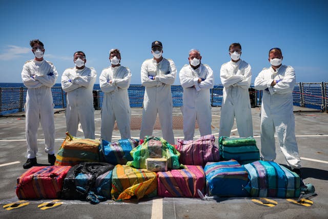 Sailors pose with seized cocaine from a narco-sub in the Caribbean