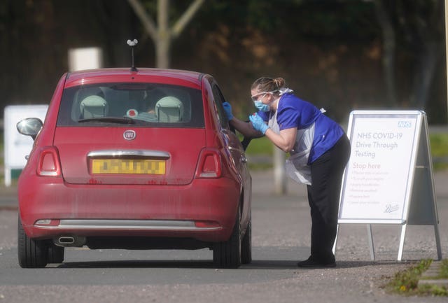 An NHS worker is tested for coronavirus at a temporary drive-through testing station in the car park of Chessington World of Adventures