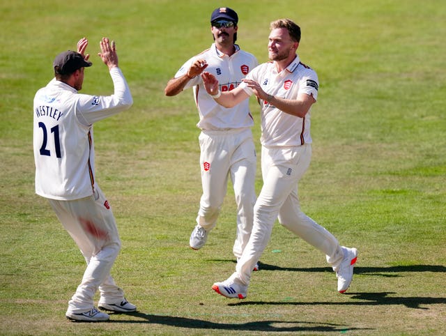 Sam Cook, right, celebrates taking a wicket