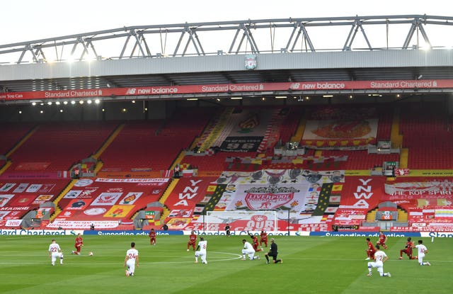 Players from Liverpool and Crystal Palace take a knee in front of an empty Kop