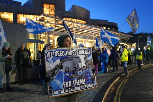 People attend a rally outside the Scottish Parliament in Edinburgh following the UK Supreme Court decision