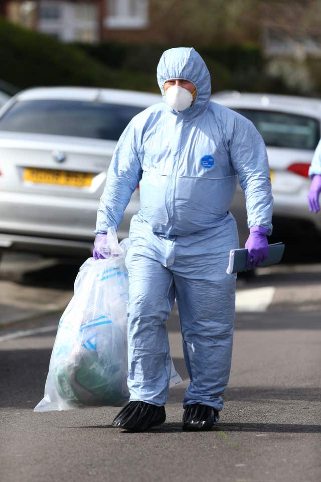 A forensic officer removes an evidence bag (Gareth Fuller/PA)