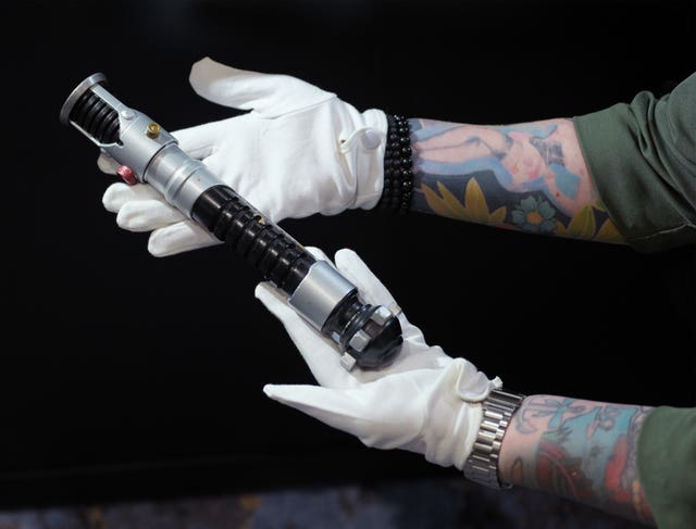 Hands holding a lightsaber