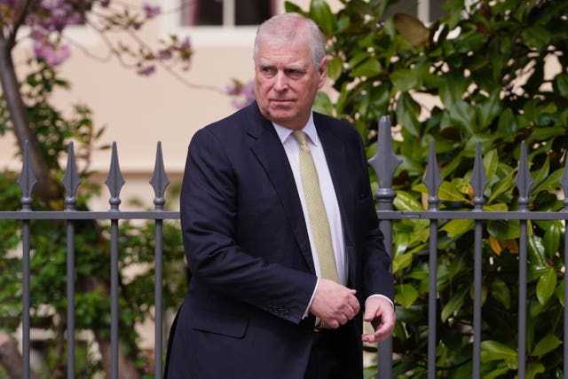 Andrew Mountbatten-Windsor walking outside, wearing a suit and tie