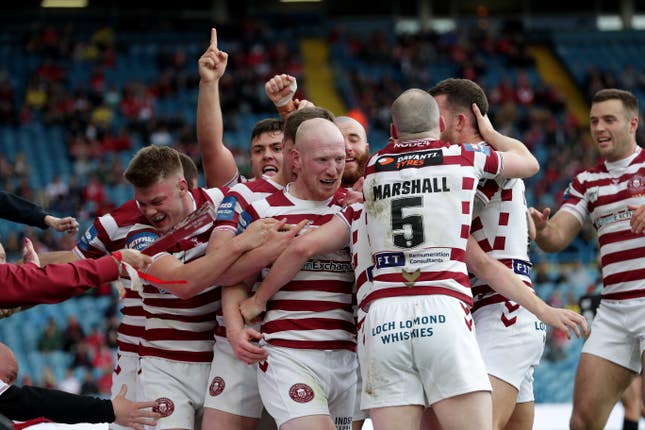 Liam Farrell (centre) celebrates a try for Wigan
