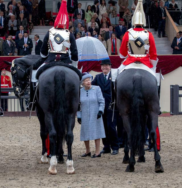 The Queen presents the award to the best turned out trooper of the Household Cavalry (Steve Parsons/PA)