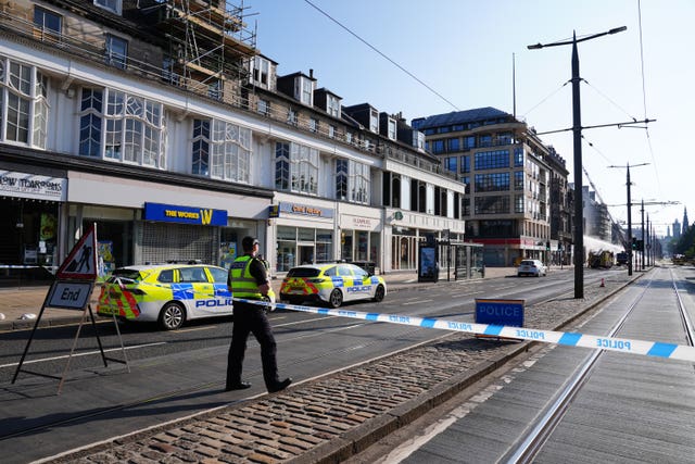 A police officer at the start of a police cordon on Prices Street