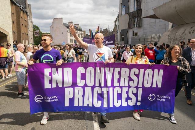 John Swinney at the head of the Edinburgh Pride march in 2024 holding a banner which says