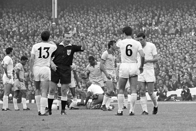 Pele (on floor) receives treatment from trainer Americo (kneeling) as referee Kurt Tschenscher (second left) warns Bulgaria's Dimitar Yakimov (13) and Dobromir Jetchev (6) (PA)