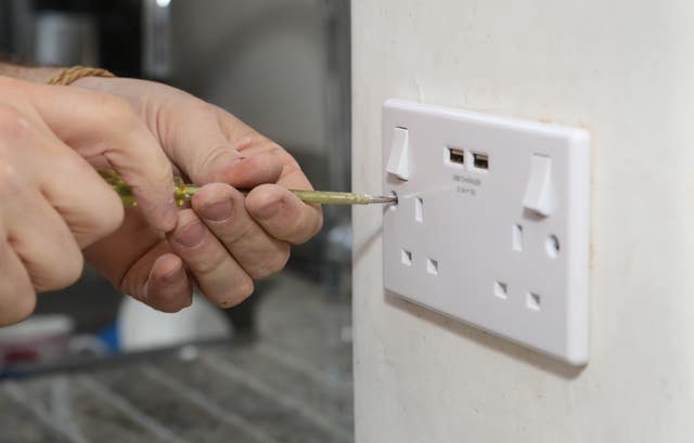 Richard Burr fitting a USB plug into a wall