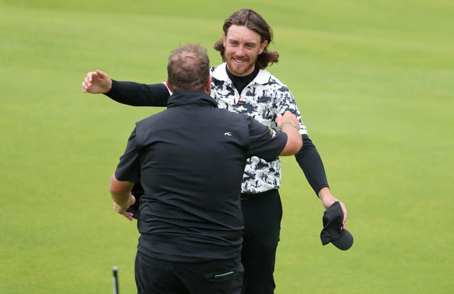 Shane Lowry, left, and England's Tommy Fleetwood embrace on the 18th