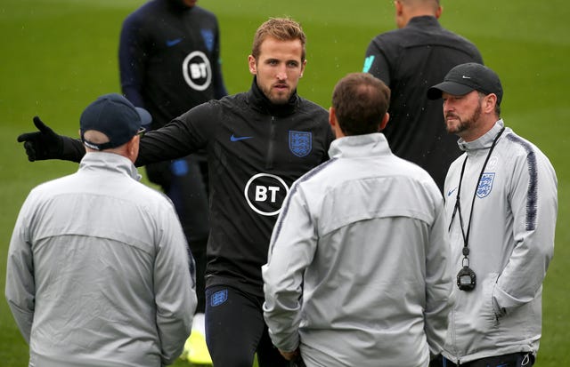  Harry Kane talks with manager Gareth Southgate and his staff