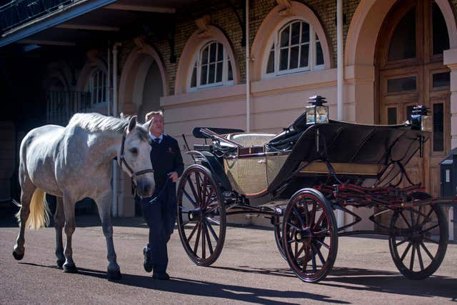 Philip Barnard-Brown, Senior Coachman, leads a Windsor Grey, one of the four horses that will pull the carriage past the Ascot Landau (Victoria Jones/PA)