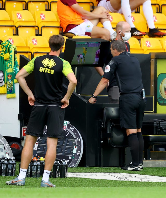 Referee Kevin Friend checks the VAR monitor in a match between Norwich and Burnley 