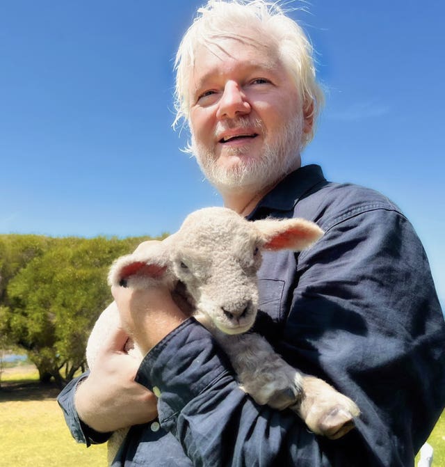 Julian Assange holding a lamb