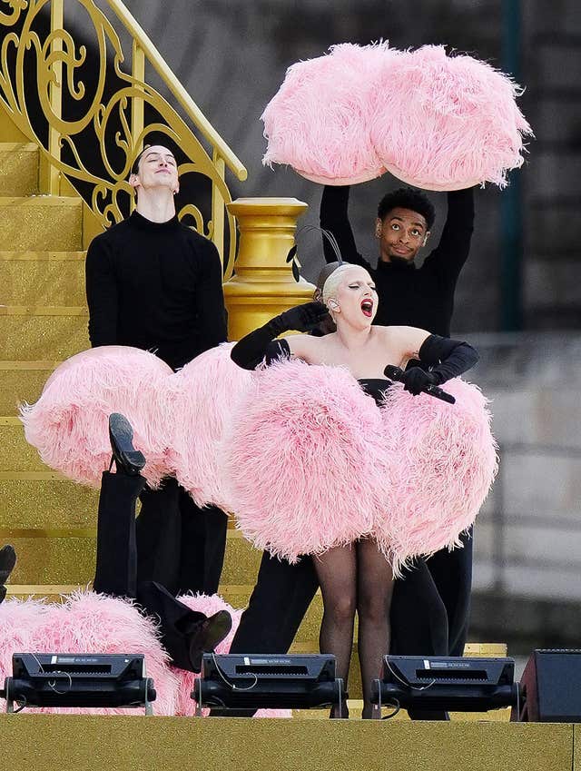 Lady Gaga performs, with pink feathered pom poms