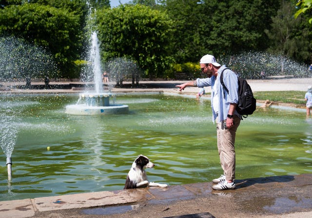Man with his dog at water fountain in Battersea Park