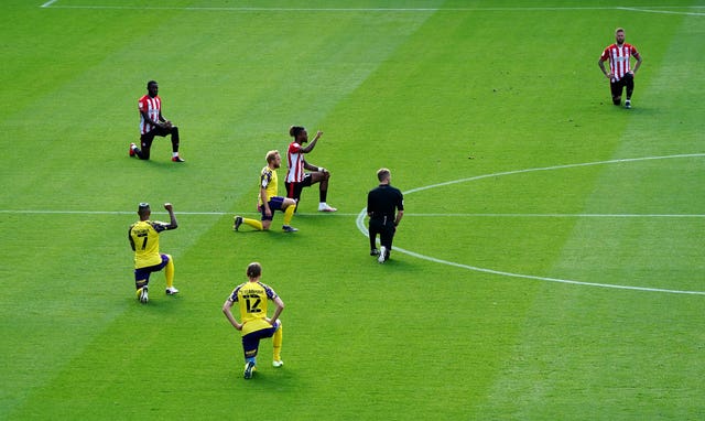 Brentford and Huddersfield players take the knee before their Championship game in September