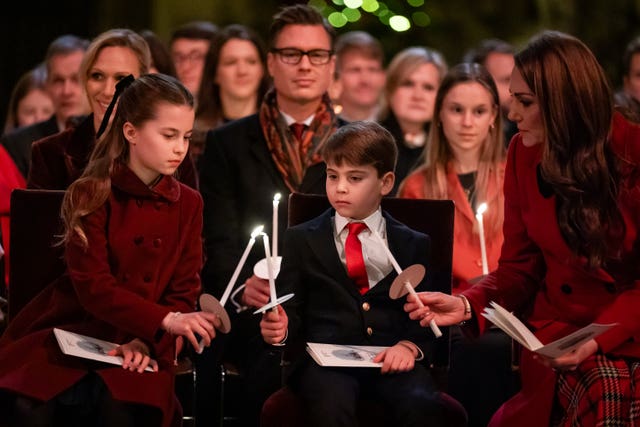 Charlotte, Louis and Kate light candles together at the Together At Christmas carol service