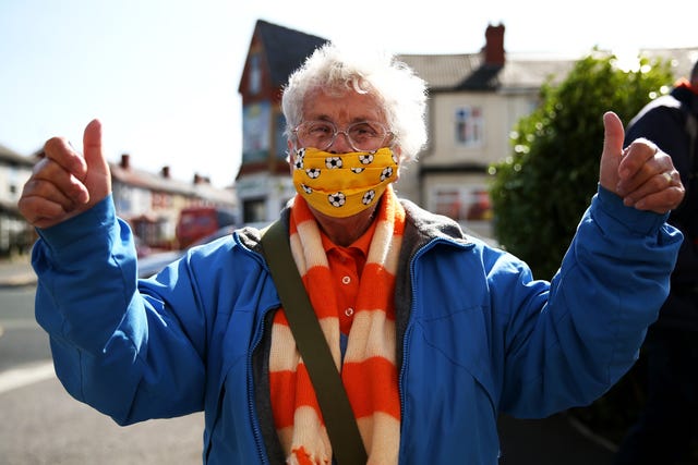 A Blackpool fan wearing a football patterned face mask poses on the way into the League One match against Swindon 