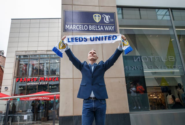David Maddison celebrates in front of a freshly installed street sign