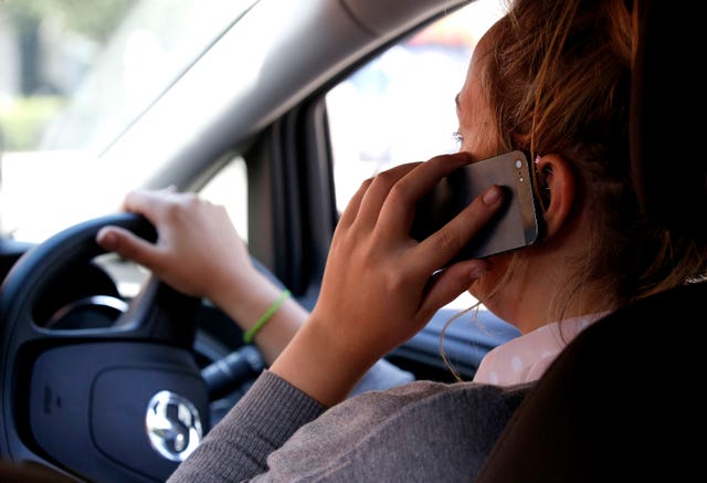 Driving while using mobile phones