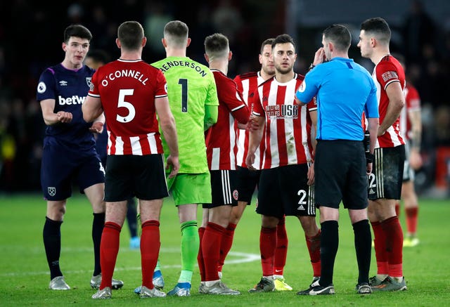 Declan Rice (far left) awaits the result of a VAR check after West Ham's injury-time equaliser was called into question and eventually disallowed due to a handball 