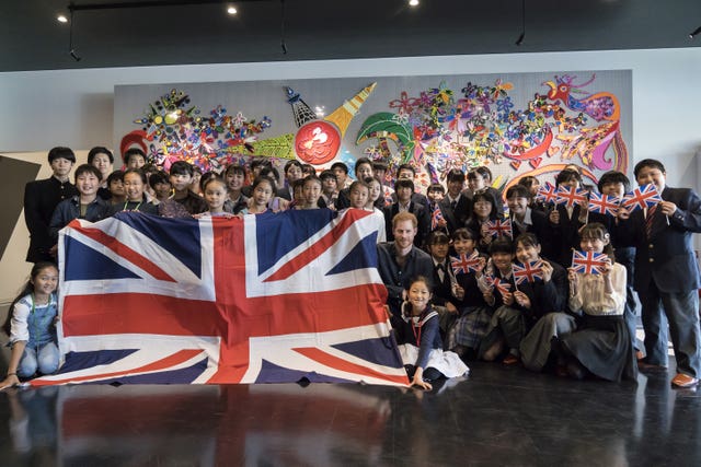 The Duke of Sussex poses with students at the Nippon Foundation Para Arena in Tokyo