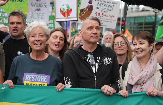 Three people holding a protest banner