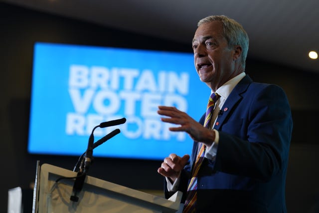 Nigel Farage making a speech with a Reform UK backdrop