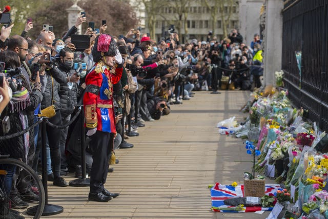 A man lays a floral tribute outside Buckingham Palace
