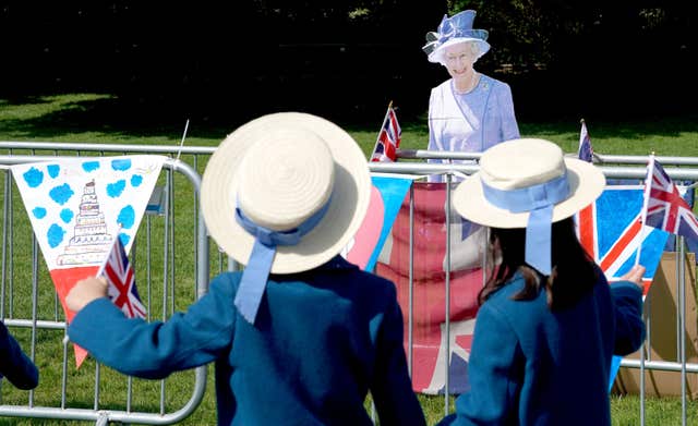The real deal? Two schoolgirls wave at a cut-out of the Queen  in Windsor (Owen Humphreys/PA)