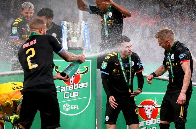 Manchester City’s Kyle Walker, left, sprays Alexander Zinchenko, right, and Phil Foden with Champagne