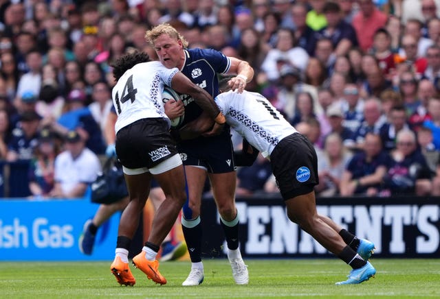 Duhan van der Merwe (centre) is tackled by Selestino Ravutaumada (left)