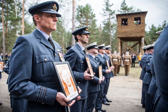 Air force personnel parade at the site of Stalag Luft III in Zagan, Poland, during a remembrance service to commemorate the 75th anniversary of the Great Escape