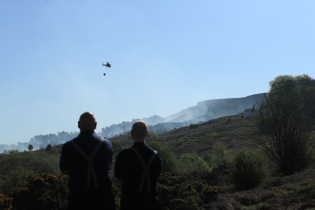 Firefighters use a helicopter to drop water on Ilkley Moor