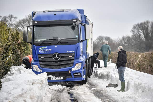 Men use shovels to try and free a lorry near Marlborough, Wiltshire (Ben Birchall/PA)
