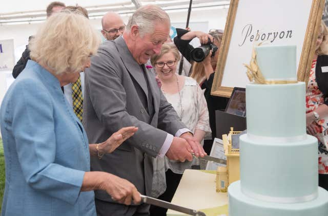 The Prince of Wales and the Duchess of Cornwall cut lemon and Cornish elderflower sponge cakes (Matt Cardy/PA)