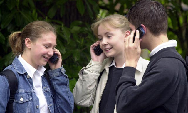 Children using mobile phones. Excessive screen time has been linked to lower levels of happiness in teenagers (Tim Ockenden/PA Images) 