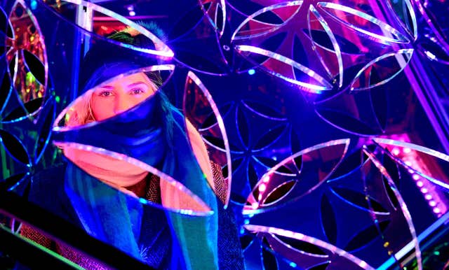 A woman looks through the Dazzling Dodecahedron (Ian West/PA)