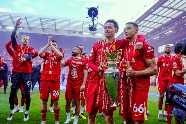 Liverpool’s Trent Alexander-Arnold, right, and Curtis Jones celebrate with the Premier League trophy