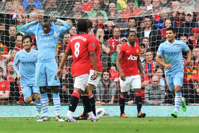 Mario Balotelli, second left, lifts his jersey to reveal a T-shirt asking ‘Why always me?' after scoring against Manchester United