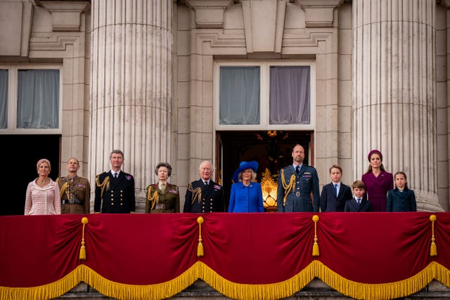Members of the royal family observe the national anthem after watching the VE Day RAF flypast